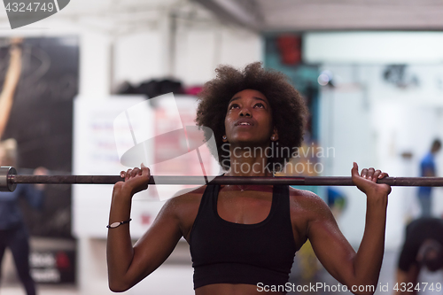 Image of black woman lifting empty bar