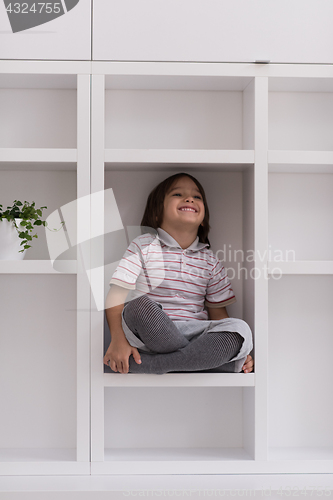 Image of young boy posing on a shelf