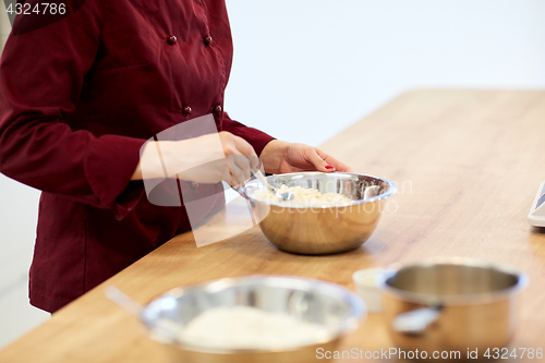 Image of chef with flour in bowl making batter or dough