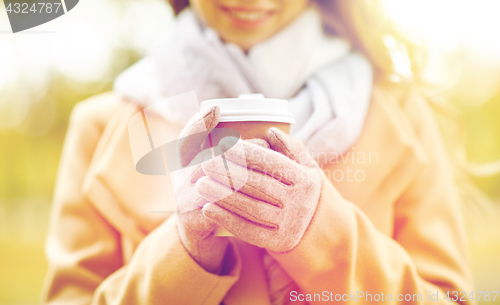Image of close up of happy woman with coffee in autumn park