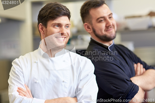 Image of happy smiling chef and cook at restaurant kitchen