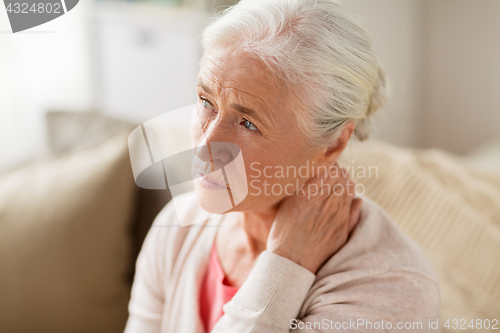 Image of senior woman suffering from neck pain at home