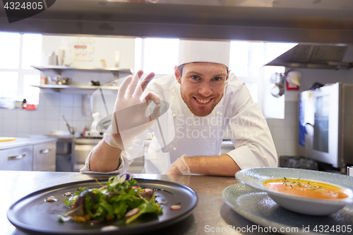 Image of happy male chef cooking food at restaurant kitchen