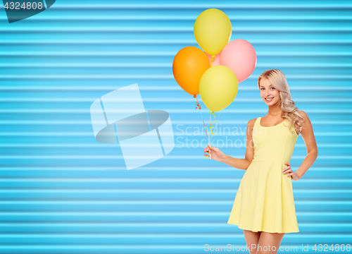 Image of happy woman in dress with helium air balloons