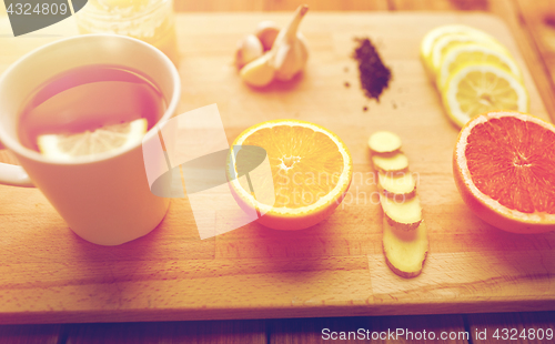 Image of ginger tea with honey, citrus and garlic on wood