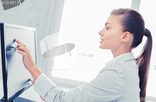 Image of smiling businesswoman with touchscreen in office