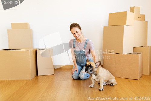 Image of happy woman with dog and boxes moving to new home