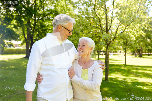Image of happy senior couple hugging in city park