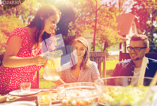 Image of happy friends having dinner at summer garden party