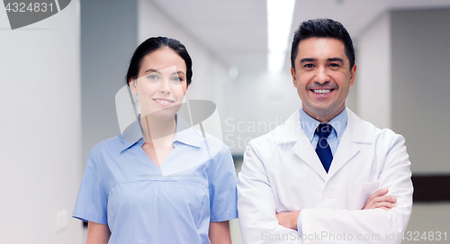 Image of smiling doctor in white coat and nurse at hospital