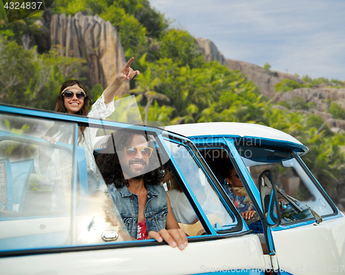 Image of happy hippie friends in minivan car on island