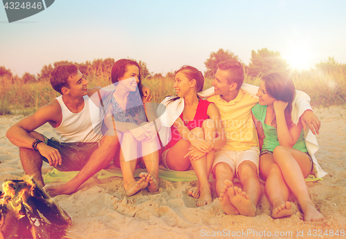 Image of smiling friends in sunglasses on summer beach