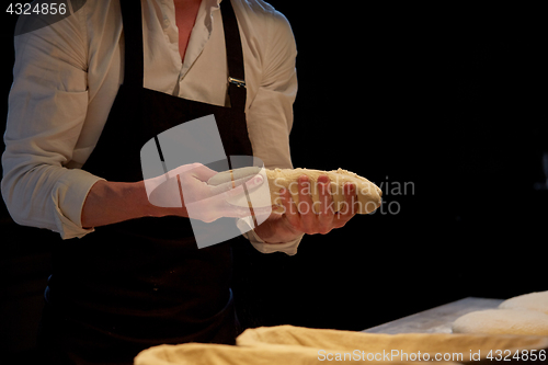 Image of baker with dough rising in baskets at bakery