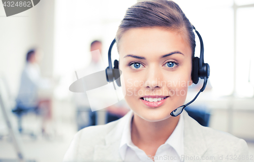 Image of helpline operator with headphones in call centre