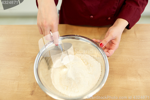 Image of chef with flour in bowl making batter or dough