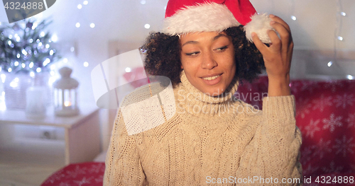 Image of Woman playing with the pompom on a Santa hat