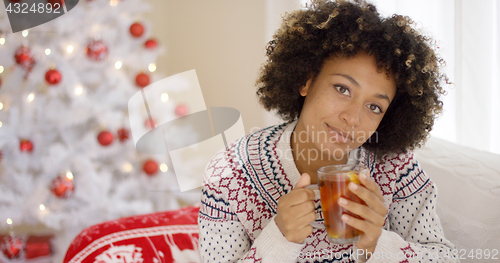 Image of Thoughtful young woman drinking a mug of tea