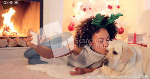 Image of Cute young woman taking a selfie with her dog