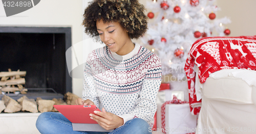 Image of Young woman surfing the internet at Christmas