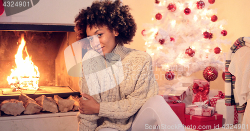 Image of Beautiful black woman seated beside white tree