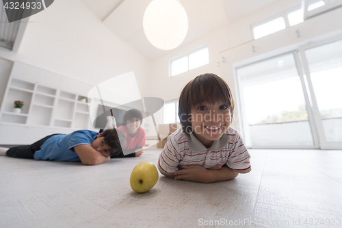 Image of boys having fun with an apple on the floor