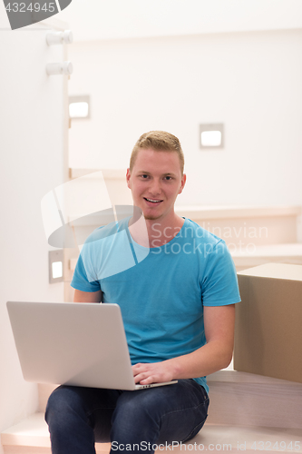 Image of young man sitting in stairway at home