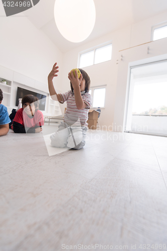 Image of boys having fun with an apple on the floor