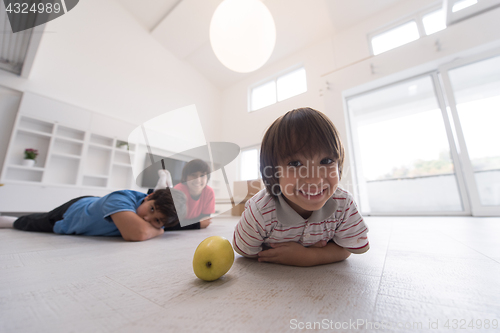 Image of boys having fun with an apple on the floor