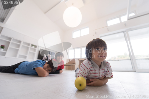 Image of boys having fun with an apple on the floor