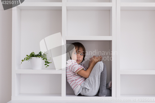 Image of young boy posing on a shelf