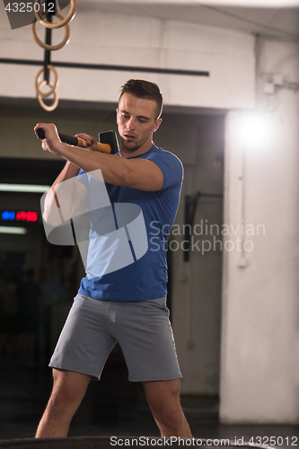 Image of man workout with hammer and tractor tire