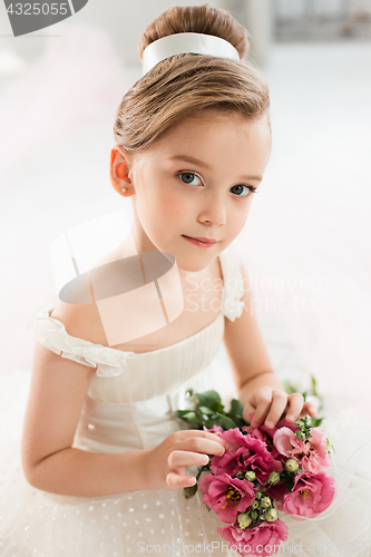 Image of The little balerina in white tutu in class at the ballet school