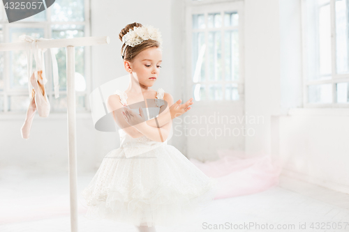 Image of Little ballerina girl in a tutu. Adorable child dancing classical ballet in a white studio.