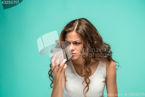 Image of The portrait of disgusted woman with mobile phone