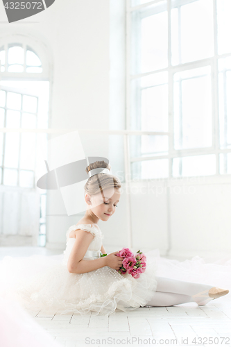Image of The little balerina in white tutu in class at the ballet school