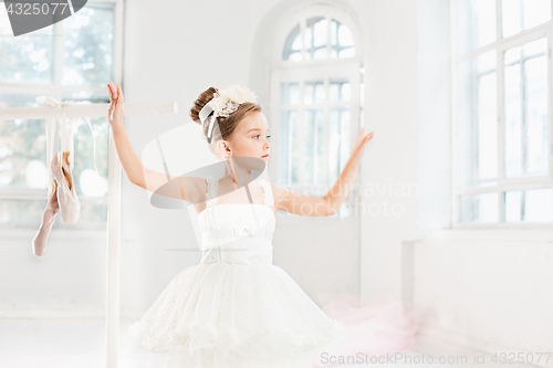 Image of Little ballerina girl in a tutu. Adorable child dancing classical ballet in a white studio.