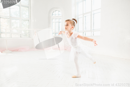 Image of Little ballerina girl in a tutu. Adorable child dancing classical ballet in a white studio.