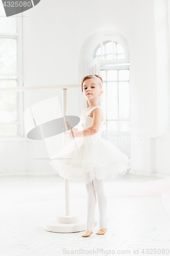 Image of Little ballerina girl in a tutu. Adorable child dancing classical ballet in a white studio.