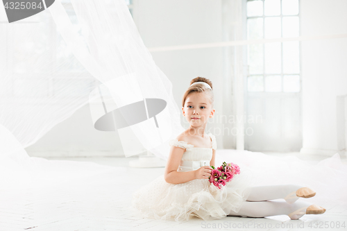 Image of The little balerina in white tutu in class at the ballet school