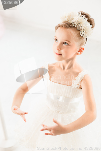 Image of Little ballerina girl in a tutu. Adorable child dancing classical ballet in a white studio.