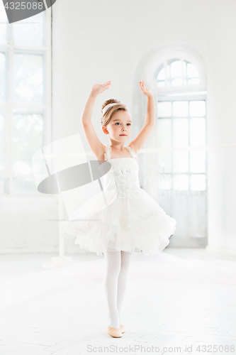 Image of Little ballerina girl in a tutu. Adorable child dancing classical ballet in a white studio.