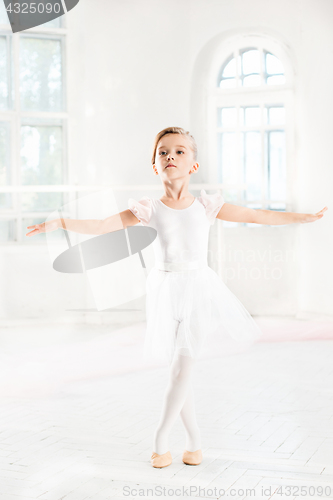 Image of Little ballerina girl in a tutu. Adorable child dancing classical ballet in a white studio.