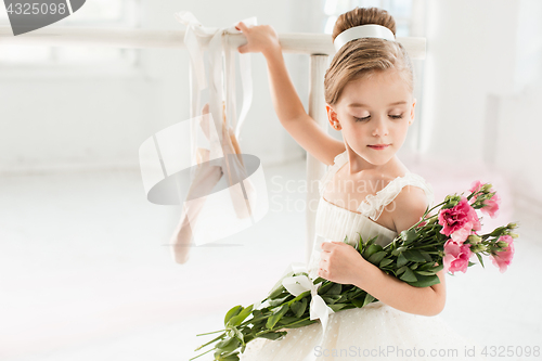 Image of Little ballerina girl in a tutu. Adorable child dancing classical ballet in a white studio.