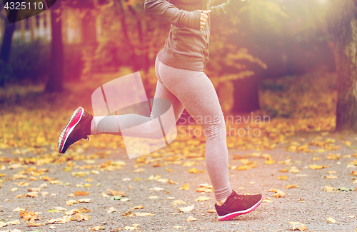 Image of close up of young woman running in autumn park