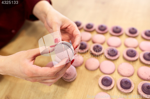 Image of chef sandwiching macarons shells with cream