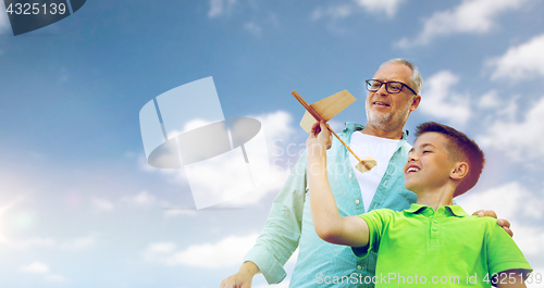 Image of senior man and boy with toy airplane over sky