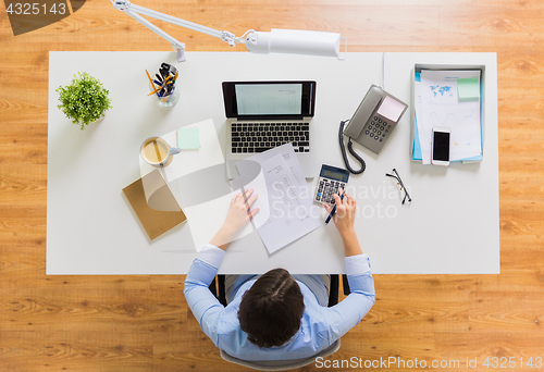 Image of businesswoman with tax report at office