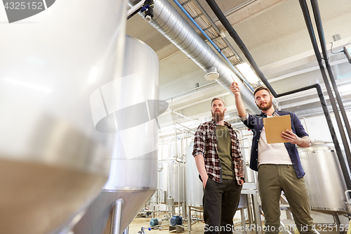 Image of men with clipboard at brewery or beer plant