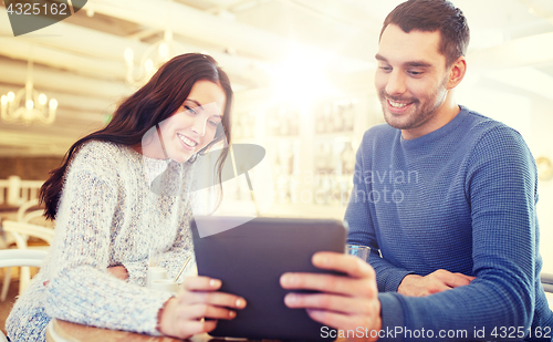 Image of happy couple with tablet pc drinking tea at cafe