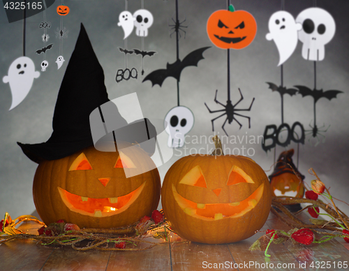 Image of carved pumpkins in witch hat and halloween garland